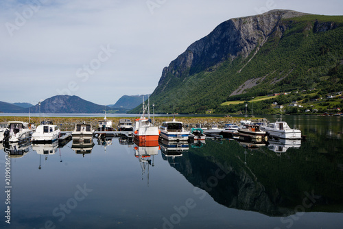Scenic Fjord Harbor in Norway: Boats Reflecting Majestic Mountains