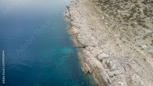 Canvastavla Aerial view of rugged rocky coastline meeting deep blue sea, with clear turquois