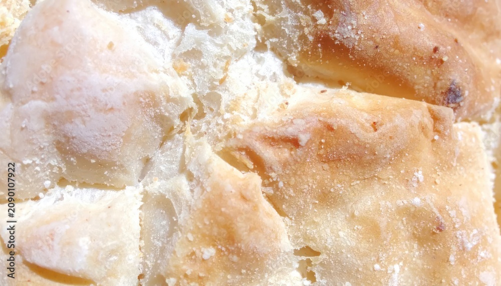 Obraz premium Golden brown crusty sourdough bread close up texture.