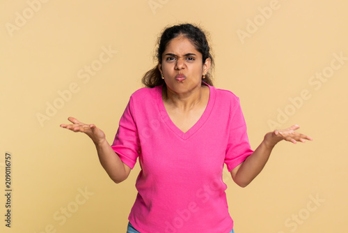 Fotografie Indian woman spreads hands in disbelief emotionally surprised questioning clear astonishment