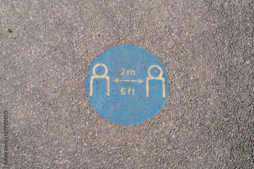 Social Distancing Marker on Asphalt Indicating 2 Meters or 6 Feet Separation