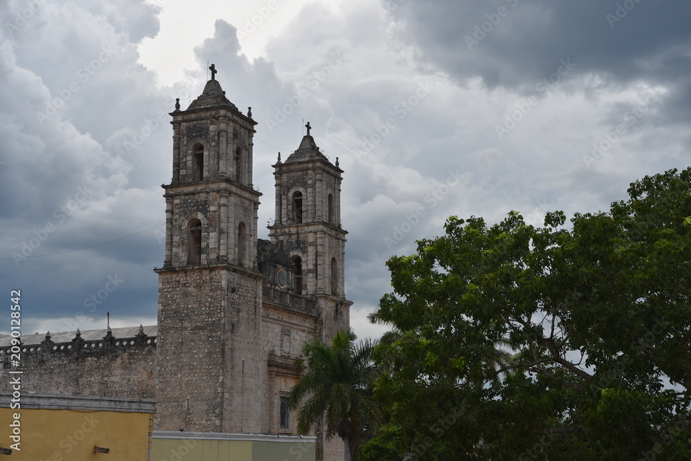 Fototapeta premium Ancient stone church bell towers against stormy clouds