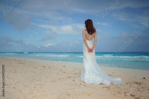 Bride in white wedding dress on caribbean beach