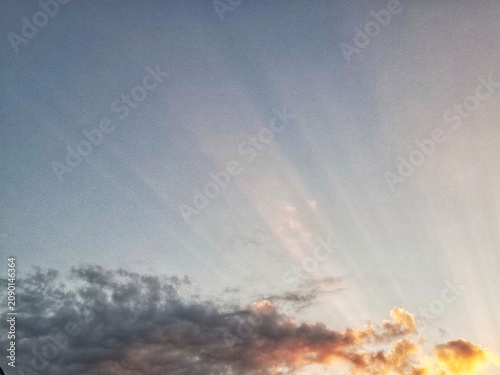 Schilderij op canvas Beautiful crepuscular rays breaking through clouds in the evening sky