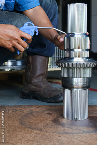 Konstfotografi Technician Cleaning Spline Shaft with Air Blow Gun.