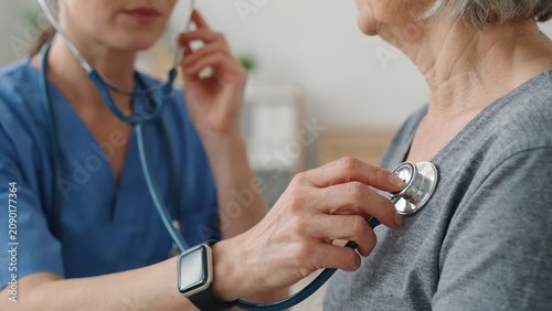 Doctor checking senior patient heart with stethoscope during medical examination