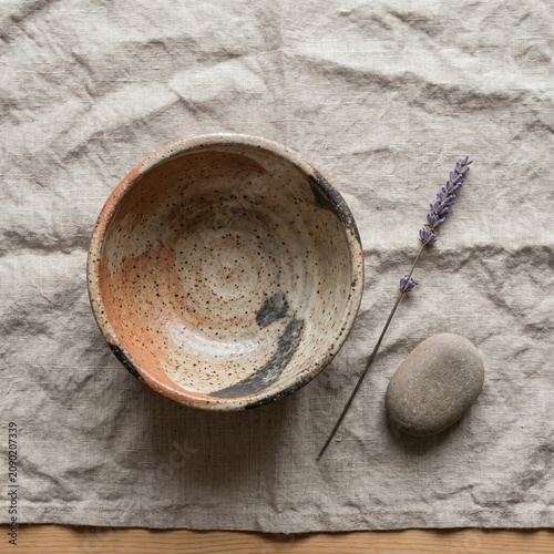 Rustic Ceramic Bowl with Lavender and Pebble on Linen Fabric