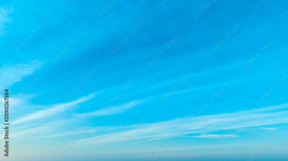 Fototapeta premium A bright, clear blue sky meets a glowing white horizon, suggesting a serene, open, and with sunlight of beautiful cloudy sky. landscape or abstract background