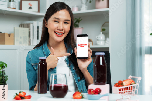 Принти на полотні Smiling young beautiful Asian reviewing tasty mixed strawberry and cherry juice detox drinks, showing healthy product to promote for special promotion selling on social media online record