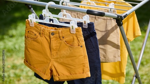 Close Up of Colorful Casual Clothes Hanging on Outdoor Drying Rack Under Bright Natural Sunlight During Laundry Day