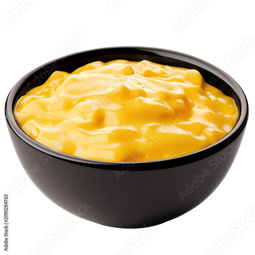 Creamy golden cheese sauce in a sleek black ceramic bowl isolated on white background