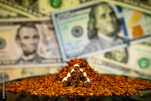 Foto Close up of cigarettes with loose tobacco and United States dollar banknotes bac