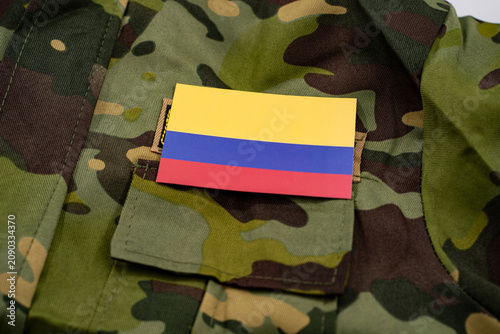 Cuadro en lienzo Colombian flag on camouflage military uniform background.