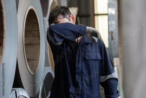 Konstfotografi Exhausted male industrial worker wearing blue uniform wiping sweat from face sta