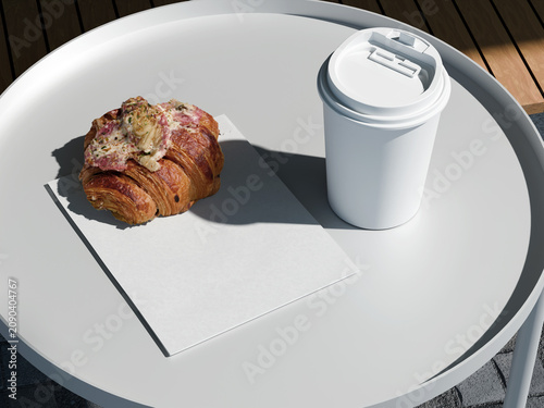 White paper coffee cup with pastry and blank paper bag on round table
