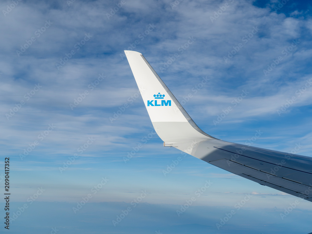 Fototapeta premium Winglet of a KLM Royal Dutch Airlines airplane flying high in the blue sky, view from the window
