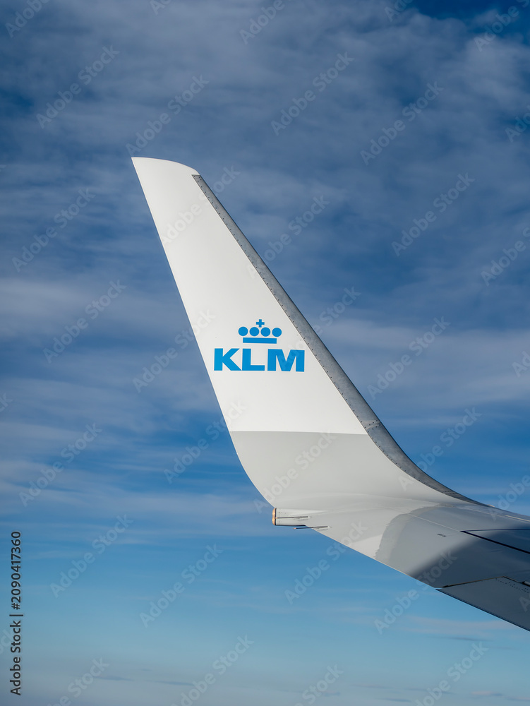 Obraz premium Winglet of a KLM Royal Dutch Airlines airplane flying high in the blue sky, view from the window