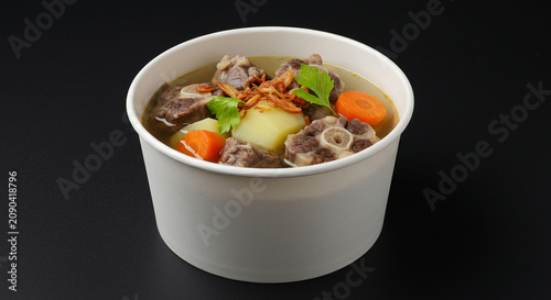 Indonesian Oxtail Soup in Takeaway Bowl on Black Background