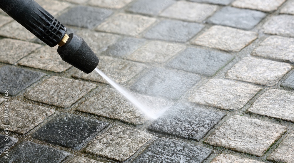 Fototapeta premium Pressure washing cobblestones on walkway