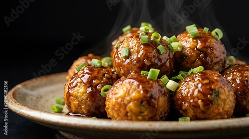 Delicious meatballs with savory sauce and fresh green onions on a rustic plate. manchurianw