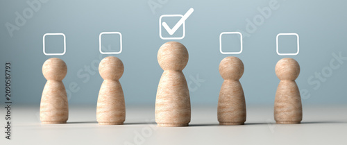 Wooden doll figures representing human resources standing in a row, choosing the best candidate with a checkmark symbol above, isolated on grey background