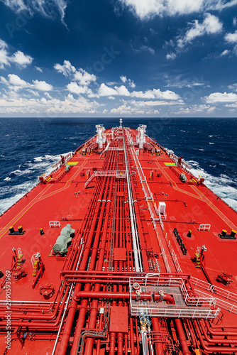 Foto Large oil tanker sailing on open sea under blue sky