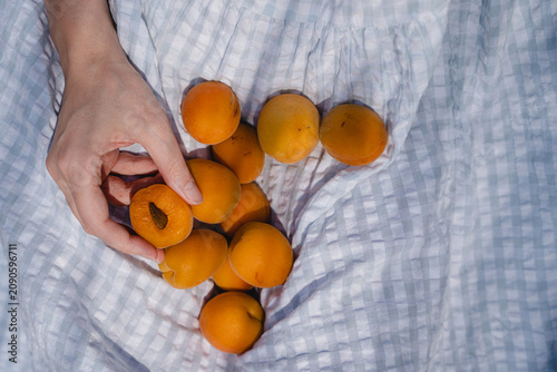 Photos Young Woman Enjoying Fresh Apricot Snack On Bright Sunny Day Wearing Light Blue