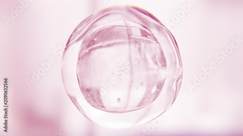 Pink anti-aging serum bubble. Luxury skincare cosmetics macro 3D abstract background. Glowing moisturizer essence gel drops. Collagen fluid molecule, peptide face lotion for skin radiance and lifting