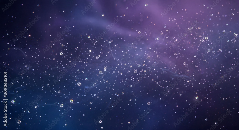 Fototapeta premium Crystal droplets floating on deep purple blue galaxy background with soft focus and sparkling particle effect