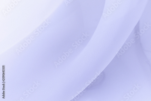 Soft delicate transparent organza, chiffon, silk fabric in lavender or lilac or light purple. Close up folds of fabric textile texture as background in pale violet color with copy space.
