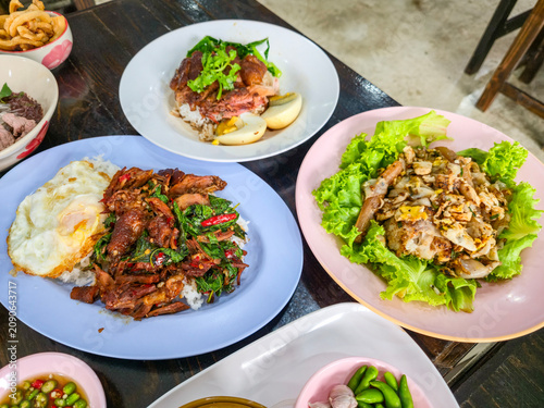 A dining table filled with authentic Thai dishes, including noodles, rice, and a variety of traditional foods, ready to enjoy.