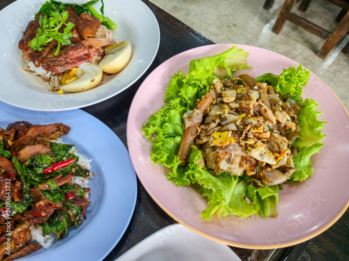 A dining table filled with authentic Thai dishes, including noodles, rice, and a variety of traditional foods, ready to enjoy.