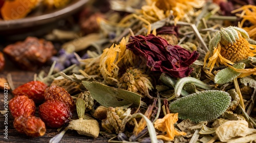 Close-up of rose hips and dried herbs on a wooden table