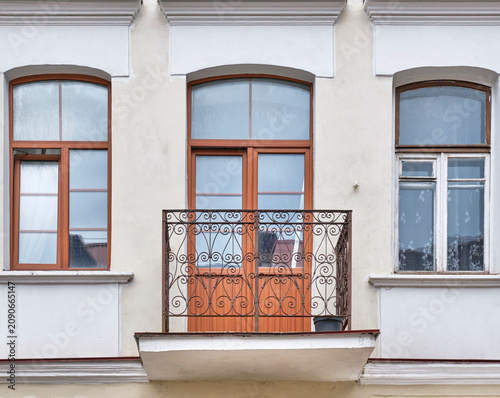 Historical building facade with wrought iron balcony and wooden windows in Minsk, Belarus.