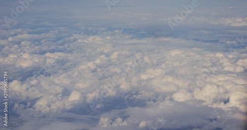Aerial view from an airplane window looking down at fluffy white clouds, 2026