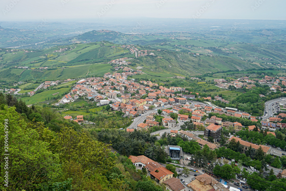 Fototapeta premium Panoramic view from the fortress of San Marino over surrounding landscape under dramatic cloudy sky