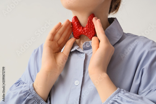 Woman holding a red thyroid...