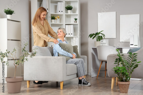 Teenage girl with pillow sitting on sofa at psychologists office