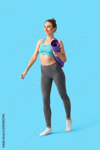Young woman with yoga mat o...