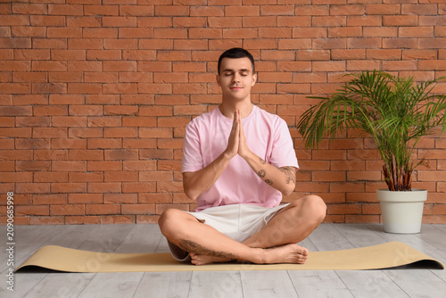 Young man meditating on yog...