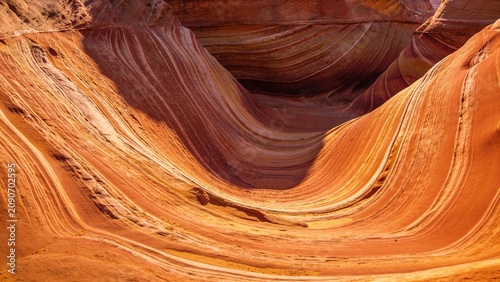 Intricate swirling patterns of layered sandstone create abstract flowing textures in a unique geological formation suitable for backgrounds and design projects.