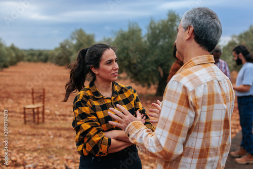 Принти на полотні Farm workers discussing agricultural business in olive grove