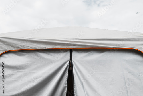 Foto A white tent is being set up under a cloudy sky as preparations for an outdoor e