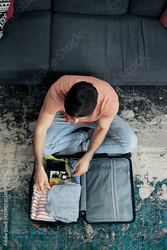 Obraz na plátně Man preparing luggage for vacation trip