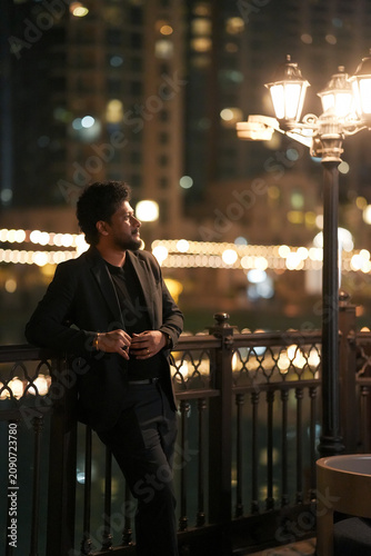 Foto Well-Dressed Young Man Standing Near Burj Khalifa in Downtown Dubai at Night