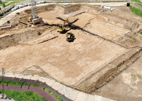 Aerial View of Construction Excavation Site With Excavator and Bulldozer Preparing Foundation.