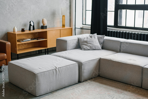 Stylish Apartment Interior with Grey Sectional Couch and Wooden Cabinet