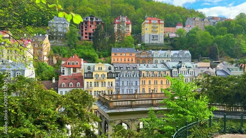 The colorful buildings and lush trees in Karlovy Vary, Czech Republic. This location showcases vibrant architecture and a lively atmosphere in the daytime.