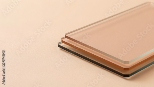 Minimalist Stack of Transparent Acrylic Glass Plates in Warm Beige and Peach Tones with Negative Space