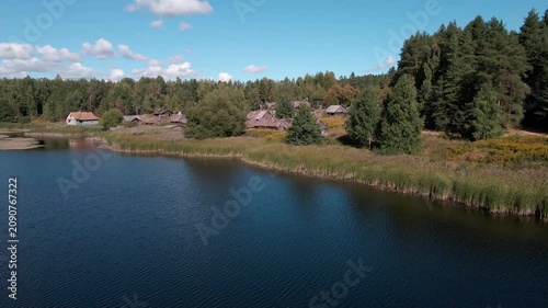 Aerial Drone Flight Over Historic Wooden Village by Lake Surrounded by Forest